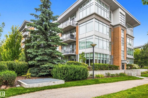 Contemporary building facade featuring expansive windows, red brick accents, and private balconies - #416 2510 109 St Nw, Edmonton, AB 