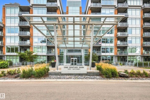 Modern multi-story building featuring extensive glazing, private balconies, and a prominent glass-and-steel entry canopy - #416 2510 109 St Nw, Edmonton, AB 