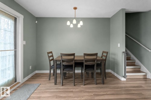Dining area featuring wood-finish flooring and a contemporary chandelier - 1303 12 Street, Cold Lake, AB 