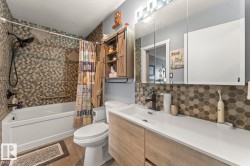 Modern bathroom featuring a single vanity with integrated sink, light wood-finish cabinetry, and a black faucet - 