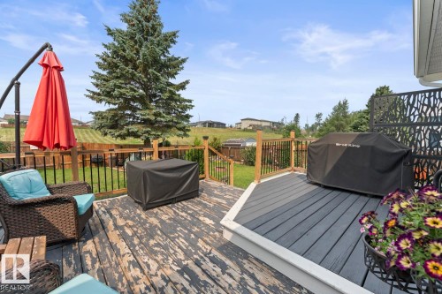 Multi-level deck featuring a black composite section, a wooden section with black painted boards, and a decorative privacy screen - 1303 12 Street, Cold Lake, AB 