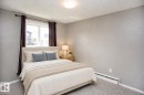 Wall-to-wall carpeting with light-colored walls and a window offering natural light. VIRTUALLY STAGED - #8 15431 93 Av Nw, Edmonton, AB 