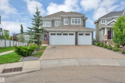 Multi-story exterior with a two-car garage, stone accents, and a concrete driveway - 