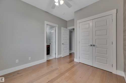 Hardwood flooring, painted walls, white trim, paneled doors, and a ceiling fan - 9054 24 Avenue Sw, Edmonton, AB 