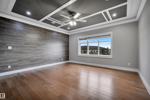 Hardwood flooring, accent wall, coffered ceiling, recessed lighting, and a ceiling fan - 9054 24 Avenue Sw, Edmonton, AB 