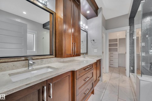 Dual vanity with undermount sinks, stone countertops, and wood-finish cabinetry - 9054 24 Avenue Sw, Edmonton, AB 