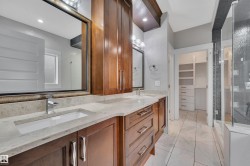 Dual vanity with undermount sinks, stone countertops, and wood-finish cabinetry - 
