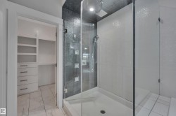 Walk-in shower with tiled walls and glass enclosure - 