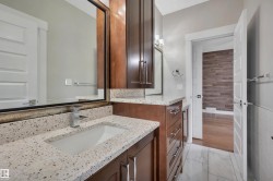 Dual dark wood-finish vanities with granite-style countertops - 