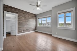 Wood-finish flooring with a textured accent wall and white trim - 
