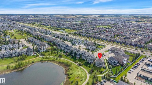 Aerial perspective of a developed residential area with a prominent pond and green spaces - 9054 24 Avenue Sw, Edmonton, AB 