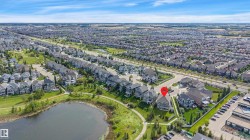 Aerial perspective of a developed residential area with a prominent pond and green spaces - 