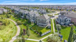 Contemporary residential architecture with multi-level balconies, expansive green space, and a paved walking path - 