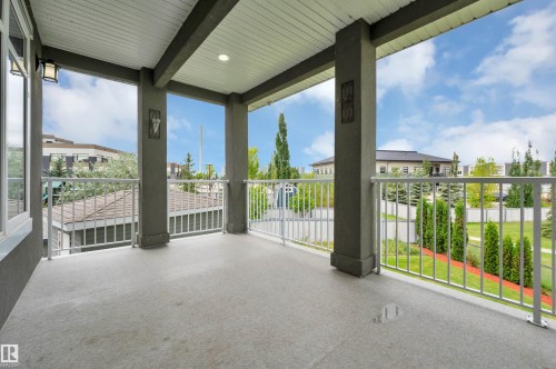 Covered outdoor balcony featuring a concrete surface, white railings, and recessed lighting - 9054 24 Avenue Sw, Edmonton, AB 