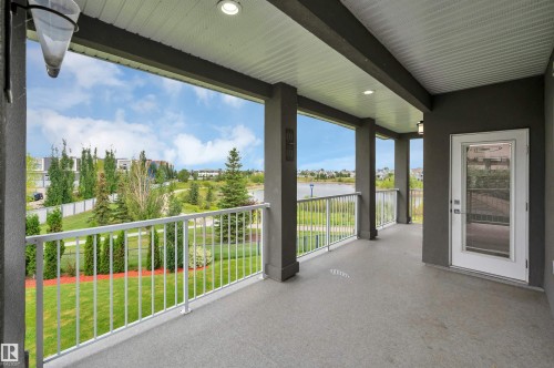 Covered balcony featuring recessed lighting, white railing, and a glass-paneled door - 9054 24 Avenue Sw, Edmonton, AB 
