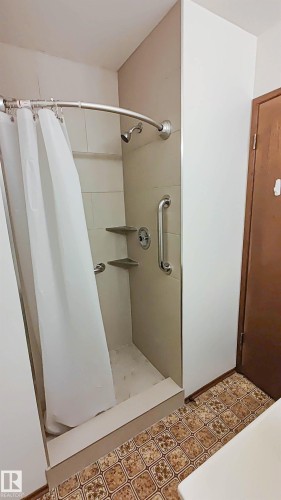 Shower stall with tile surround, built-in shelving, and grab bars - 3031 79 Street Nw, Edmonton, AB 