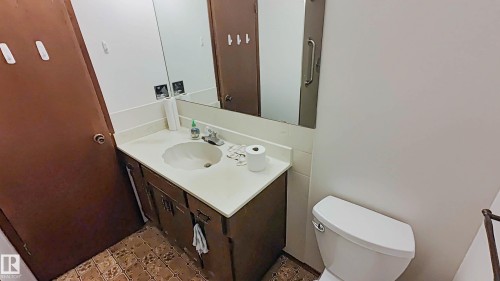Vanity with integrated sink, laminate countertop, and wood-finish cabinetry - 3031 79 Street Nw, Edmonton, AB 