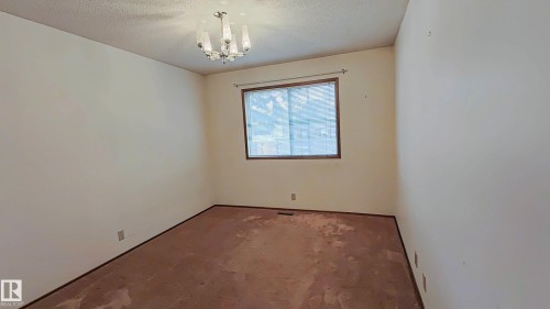 Window with wood-finish trim, chandelier light fixture, and textured ceiling - 3031 79 Street Nw, Edmonton, AB 