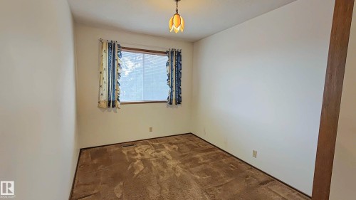 White painted walls, wood-trimmed window, and ceiling-mounted light fixture - 3031 79 Street Nw, Edmonton, AB 