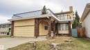 Brick exterior with an integrated garage, arched entryway, and upper-level balcony with ornate iron railing - 3031 79 Street Nw, Edmonton, AB 
