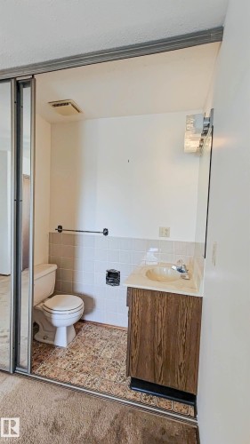 Wood-finish vanity with an integrated sink and tiled backsplash - 3031 79 Street Nw, Edmonton, AB 