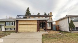 Brick facade, integrated garage, concrete driveway, arched entryway, and upper-level balcony - 
