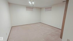 Light-toned carpeting, neutral wall finishes, and a flush-mount ceiling light fixture with three exposed bulbs - 
