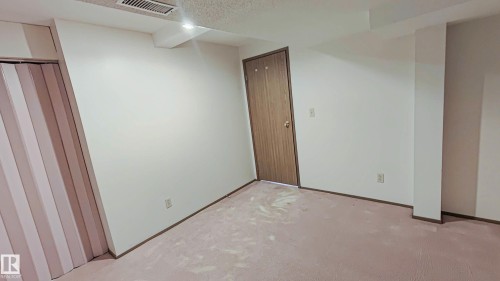 Neutral wall paint, plush carpet flooring, wood-finish bi-fold closet doors, and recessed ceiling lighting - 3031 79 Street Nw, Edmonton, AB 