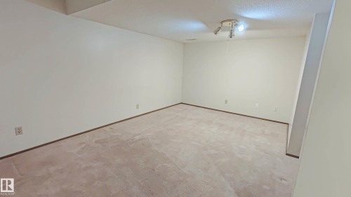 Carpeted room with neutral wall tones and track lighting - 3031 79 Street Nw, Edmonton, AB 