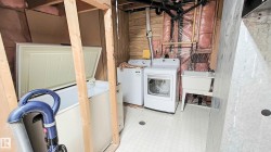 Utility area with washer, dryer, and a freestanding utility sink - 