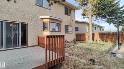 Private backyard featuring a wooden deck, sliding glass patio door, and wood fence - 