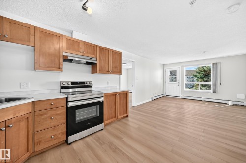 Kitchen featuring wood-finish cabinetry, stainless steel range, and white countertops - #1303 330 Clareview Station Dr Nw, Edmonton, AB 