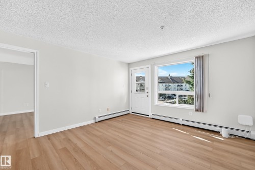 Wood-finish flooring, neutral wall tones, white trim, and a window with exterior views - #1303 330 Clareview Station Dr Nw, Edmonton, AB 