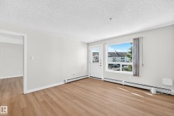 Wood-finish flooring, neutral wall tones, white trim, and a window with exterior views - 