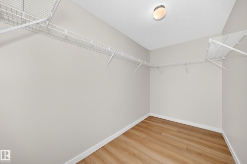 Built-in wire shelving, wood-finish flooring, recessed lighting, and neutral wall tones - #1303 330 Clareview Station Dr Nw, Edmonton, AB 