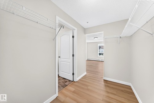 White wire shelving, wood-finish flooring, white trim, and a white interior door - #1303 330 Clareview Station Dr Nw, Edmonton, AB 