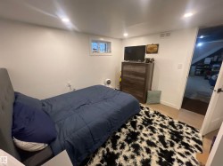 Recessed lighting, wood-finish flooring, and a window with white trim - 