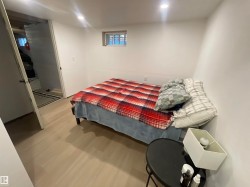 Recessed ceiling lighting, a window with exterior visibility, light wood-finish flooring, and a solid door - 