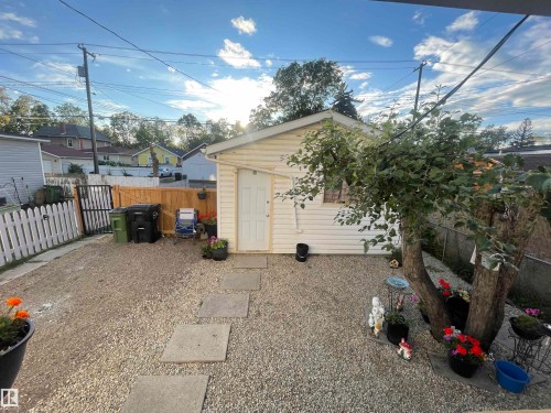 Gravel-covered yard with a detached storage shed, stepping stone pathway, and wood privacy fencing - 11230 96 Street Nw, Edmonton, AB 