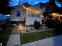 Enclosed front yard with a wrought iron fence, mature landscaping, and a concrete walkway - 11230 96 Street Nw, Edmonton, AB 