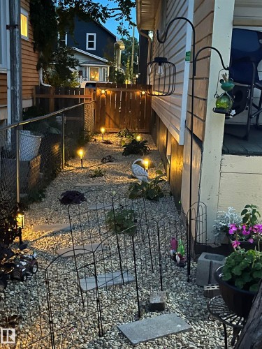 Gravel pathway with stepping stones, bordered by a wooden privacy fence and chain link fencing - 11230 96 Street Nw, Edmonton, AB 