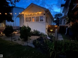 Exterior featuring horizontal siding, multiple windows, a decorative metal fence, a stone pathway, and a wood privacy fence - 