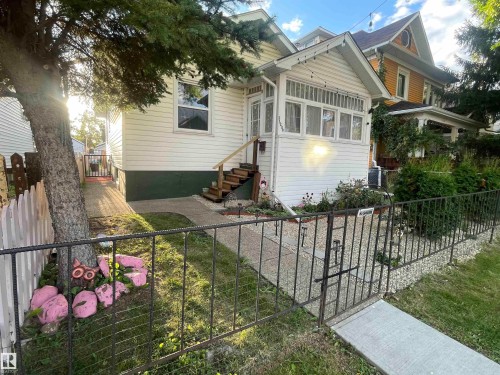 Gabled porch with multiple windows, wooden steps, and white siding - 11230 96 Street Nw, Edmonton, AB 