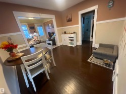 Dark-tone wood-finish flooring, two-tone painted walls with white trim, and white painted door frames create a cohesive interior - 
