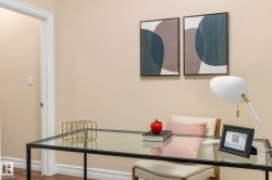 Glass-top desk with a metal frame, wood-finish flooring, and light-toned wall paint - 