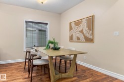 Wood-finish flooring, neutral wall color, white trim, and a window with blinds - 