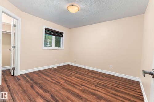 Wood-finish flooring, neutral wall tones, window with horizontal blinds, built-in closet, and a ceiling-mounted light fixture - 10143 123 Street Nw, Edmonton, AB 