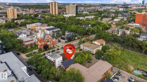 Aerial perspective showcasing urban surroundings with mature trees and a prominent red brick church - 10143 123 Street Nw, Edmonton, AB 