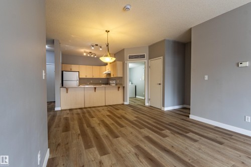 Open-concept living space with wood-finish flooring - #412 4304 139 Av Nw, Edmonton, AB - Indoor Photo Showing Kitchen