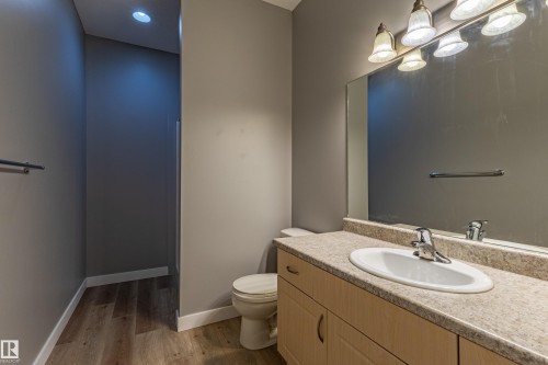 Bathroom featuring a light-toned wood-finish vanity with an integrated sink and chrome faucet - #412 4304 139 Av Nw, Edmonton, AB - Indoor Photo Showing Bathroom
